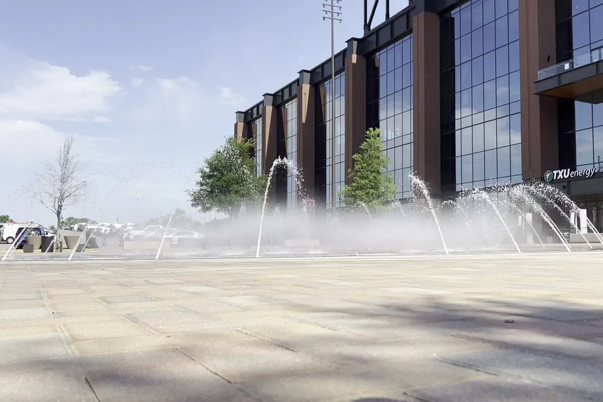 Water jets from the in-ground plaza fountains running in front of the Globe Life Field facade