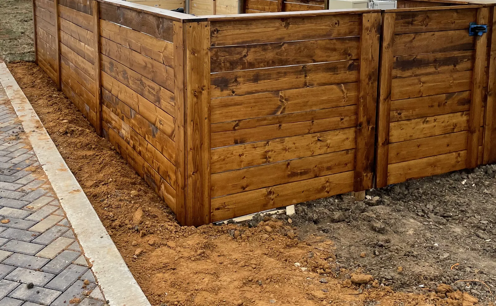 Stained wood equipment enclosure fence at Hollyhock in Frisco, TX, built by Lucent Pools