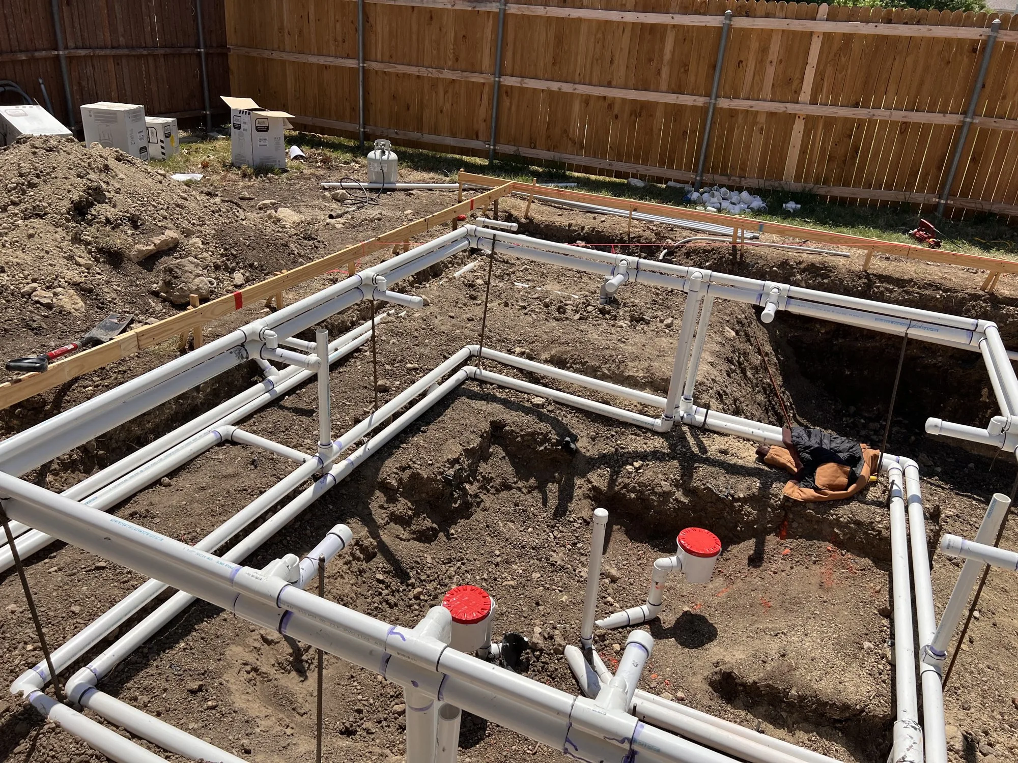White plumbing pipes laid in a Lucent pool excavation
