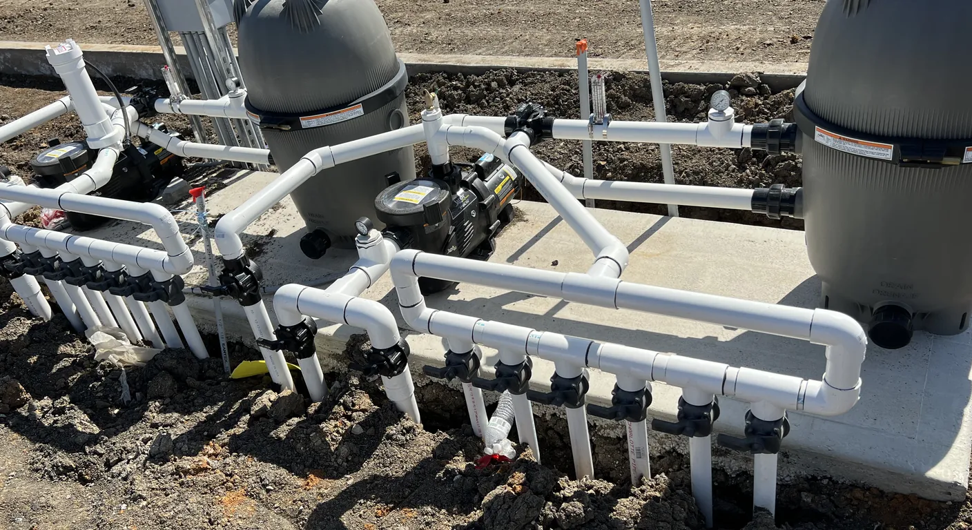Close-up of two large cartridge filters, pumps, and a valve manifold on the equipment pad for the Hollyhock center fountain in Frisco, TX