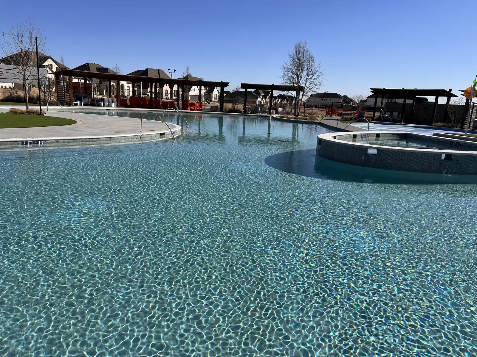 Resort-style community pool with a raised spa and pergolas